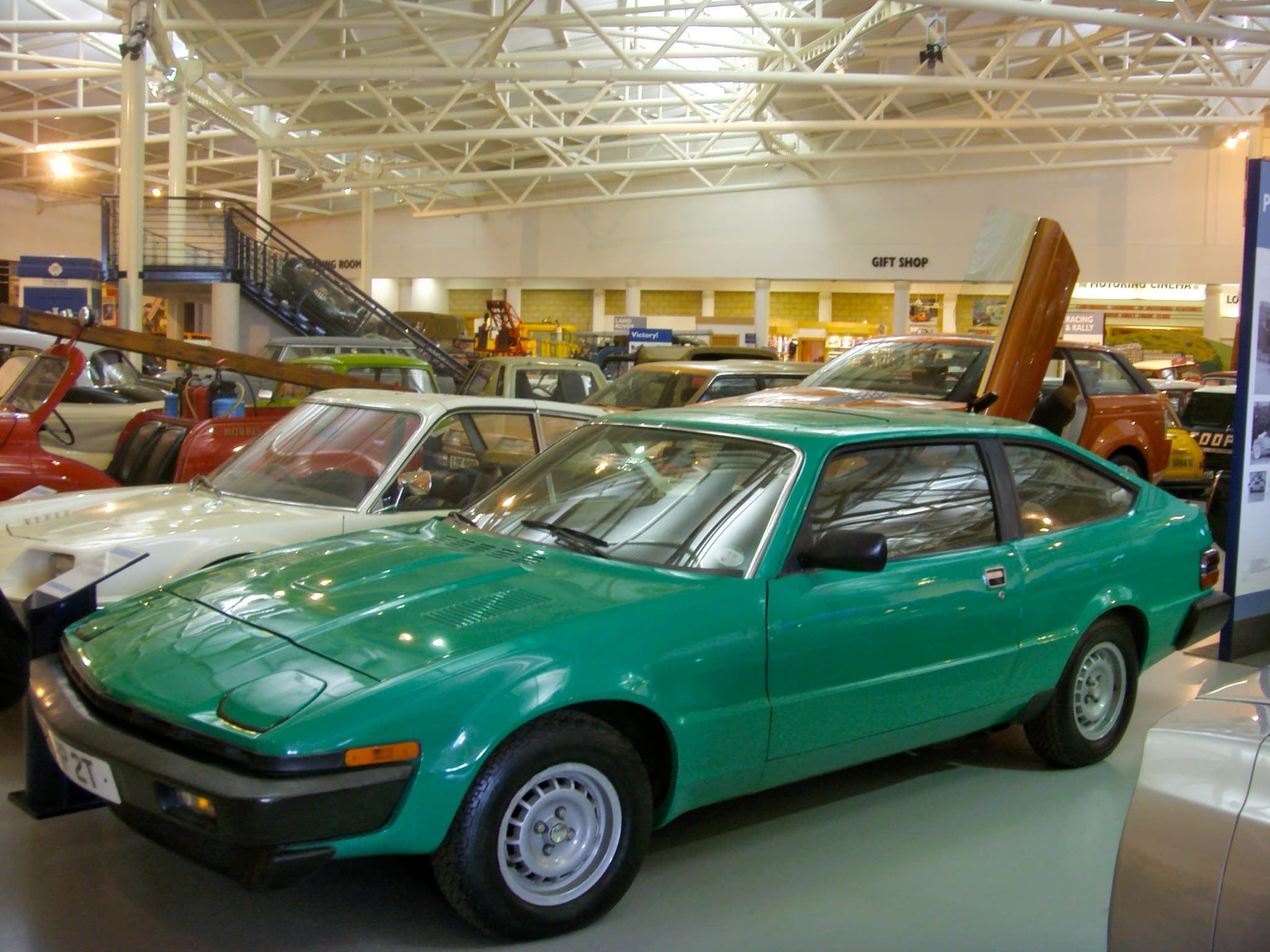 A green hatchback coupé with a wedge nose in a museum hall. Opens a larger view