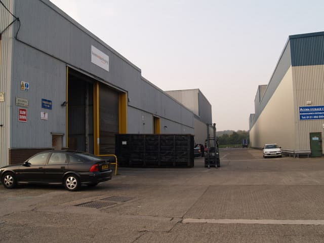 Grey industrial units and a loading yard on a trading estate.
