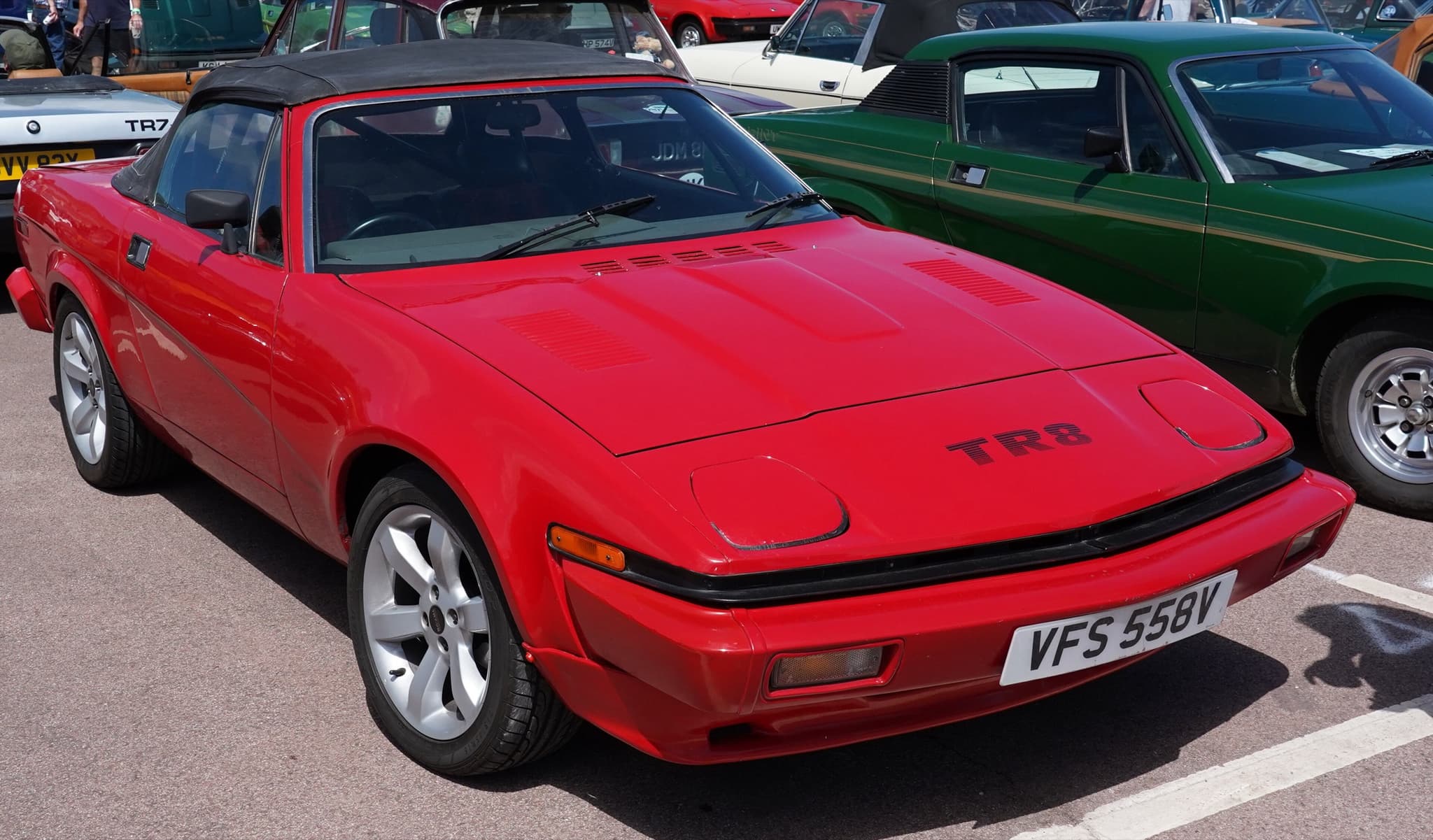 A red convertible with its hood up and a TR8 badge on its nose.