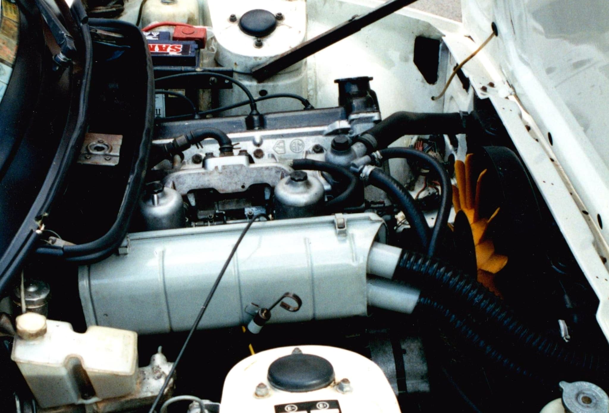 An engine bay seen from the right, with the inclined four-cylinder engine and its ancillaries.
