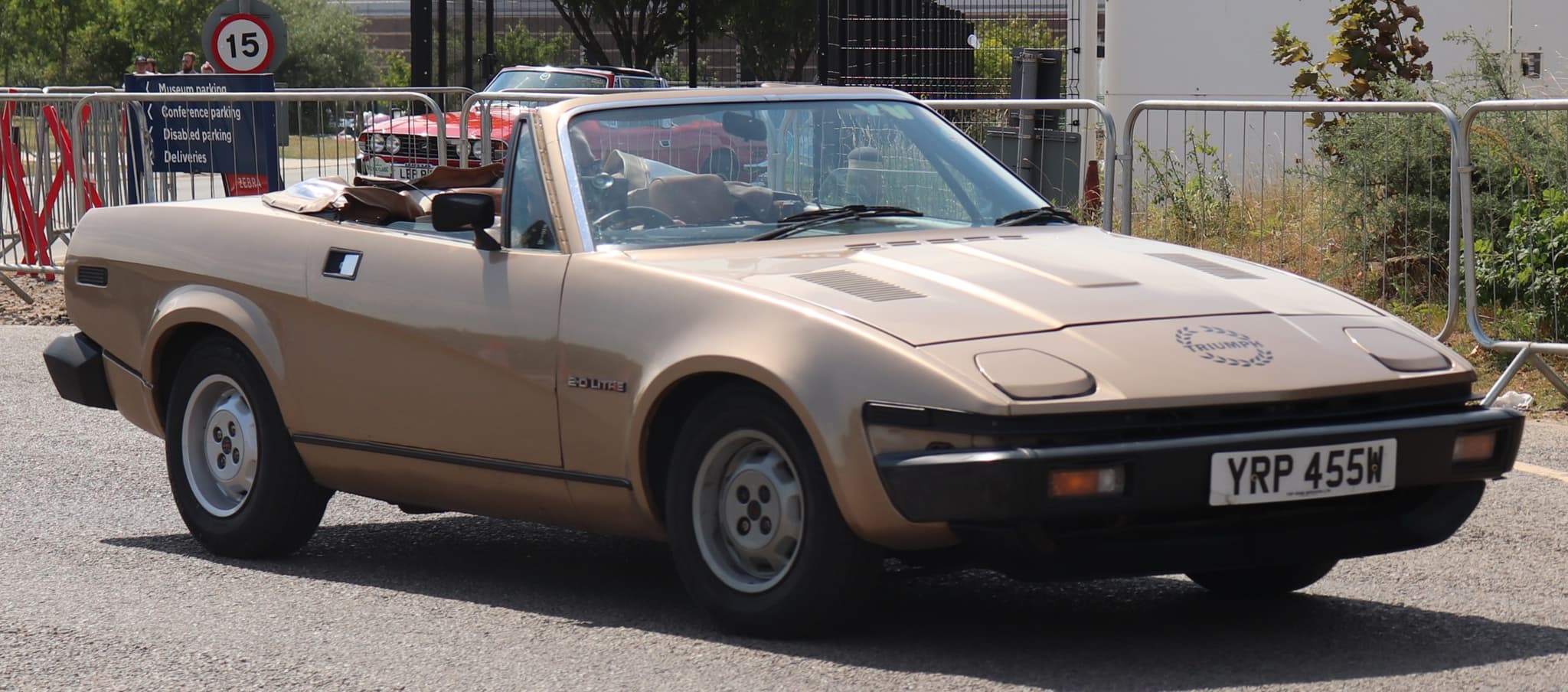 A gold convertible with its hood down, a laurel-wreath decal and a 2.0 Litre badge on the front wing.